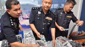PAJARI (tengah) memeriksa barang-barang yang dirampas oleh Pasukan Polis Marin Sandakan.
