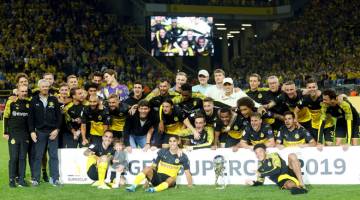 RAIKAN BERSAMA: Pemain dan kru pasukan Dortmund meraikan kejayaan mereka selepas menewaskan Bayern dalam perlawanan Piala Super Jerman di Dortmund. — Gambar Reuters
