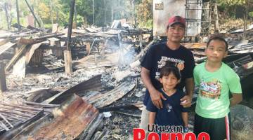 PILU: James (kiri) bersama dua anaknya hanya mampu melihat rumah mereka yang terbakar