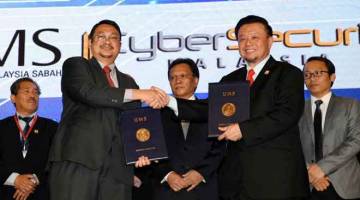 ERAT HUBUNGAN: Mohd Shafie ketika menyaksikan pertukaran dokumen perjanjian antara Naib Canselor Universiti Malaysia Sabah (UMS) Prof Dr Taufiq Yap Yun Hin (dua, kanan) dengan Ketua Pegawai Eksekutif Cyber Security Malaysia Dr Amirudin Abdul Wahab (dua, kiri) selepas melakukan perasmian Simposium IT Sabah 2019 di Dewan Bangkuasi Pusat Pentadbiran Negeri Sabah (PPNS) semalam. — Gambar Bernama