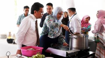 PERHATI: Shafie isterinya melakukan demonstrasi masakan pada Majlis Pelancaran Buku Resepi Masakan Datin Seri Shuryani Shuaib bertajuk 'Curry Leaves' yang dilancarkan oleh Timbalan Ketua Menteri Sabah Datuk Christina Liew.