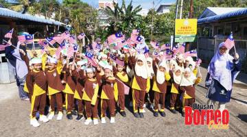 KIBAR: Pelajar Pasti Nurul Najah II berarak mengibarkan bendera Malaysia di sekitar kawasan sekolah.