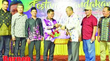 CENDERAHATI: Mohd Hamsan (tiga kanan) menyampaikan cenderahati kepada Arifin sempena Majlis Perasmian Festival Sandakan 2019.