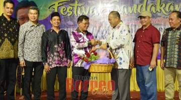 PROMOSI SANDAKAN: Mohd Hamsan (tiga kanan) menyampaikan cenderahati kepada Arifin sempena Majlis Perasmian Festival Sandakan 2019.