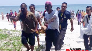 MAYAT: Penduduk kampung mengusung mayat mangsa sebaik tiba di kawasan pantai.