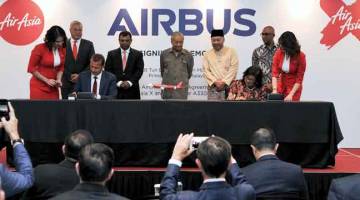 TINGKAT EKONOMI: Tun Dr Mahathir menyaksikan Pengerusi Air Asia X Berhad Tan Sri Rafidah Aziz (duduk, kanan) dan Ketua Pegawai Eksekutif Airbus Kuala Lumpur Guillaume Faury (duduk, kiri) menandatangani kontrak pembelian 12 pesawat Airbus A330neo dan 30 pesawat A321XLR pada Majlis Menandatangani Perjanjian Usaha Sama di antara Airbus dan Kumpulan AirAsia semalam. — Gambar Bernama