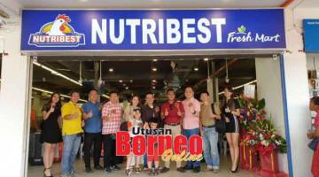 KINI DIBUKA: Aziz (empat kanan) bersama Ngu (lima kanan) bersama pegawai Nutribest Fresh Mart lain serta ahli keluarga Ngu merakam kenangan di hadapan outlet baharu di Wisma Wan, Kuching selepas majlis perasmian pembukaannya semalam.