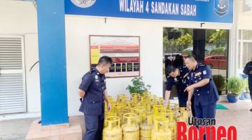 RAMPAS: Pajeri (kanan) bersama Pegawai Pemerintah Marin Sandakan DSP Rusdin Banin (kiri) memeriksa tong gas di Markas Operasi Pasukan Polis Marin Sandakan.