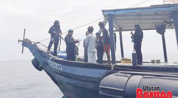 RONDAAN: Polis Marin memeriksa kapal nelayan.