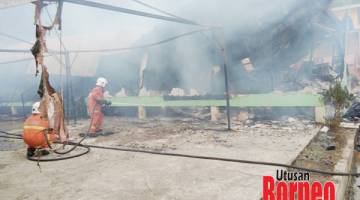 PADAM: Anggota bomba melakukan operasi pemadaman menggunakan sumber air dari jentera bomba.