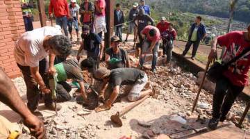 GALI: Penduduk setinggan menggali tanah di bawah arahan polis untuk mencari jasad manusia di bekas rumah Stroessner di Ciudad del Este, Paraguay kelmarin. — Gambar AFP