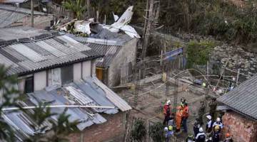 TRAGIK: Anggota penyelamat menjalankan tugas di tempat kejadian yang mengenai kawasan kejiranan Junin di Popayan, barat daya Colombia kelmarin. — Gambar AFP
