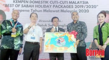CENDERAHATI: Shafie (tengah) menerima cenderahati daripada Ketua Pengarah Tourism Malaysia Datuk Musa Yusof (dua kanan). Turut kelihatan Menteri Pelancongan, Seni dan Budaya Datuk Mohamaddin Ketapi (dua kiri).