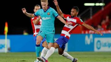 TIDAK BERI PELUANG: Pemain Barca, Frenkie de Jong (tengah) bersaing dengan pemain Granada,  Yangel Herrera (kanan) ketika beraksi pada perlawanan La Liga Sepanyol di  Nuevo Estadio de Los Carmenes, Granada kelmarin. — Gambar Reuters