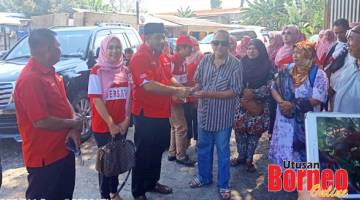 SUMBANGAN: Abdul Hakim menyampaikan sumbangan kepada keluarga mangsa kebakaran di Pasar Malam, Kampung Jaya Baru, sambil diperhatikan oleh Mizma dan Armada Bersatu Silam.