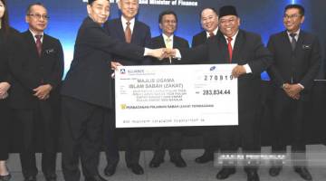 ZAKAT: Hasbullah (dua dari kiri) menerima bayaran zakat dari PPS bagi pihak Pusat Zakat Sabah.