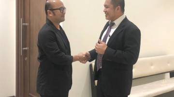 LEGA: Mohd Syamsul (kiri) berjabat tangan dengan Hamid.