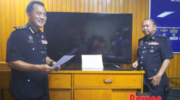 RAMPASAN: Peter (kiri) menunjukkan sebuah televisyen 60 inci yang dirampas daripada seorang suspek dalam kes pecah rumah di Tawau.