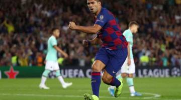 SENTUHAN BERBISA: Reaksi Suarez selepas menjaringkan gol pertama Barca ketika beraksi pada perlawanan Liga Juara-Juara menentang Inter di Nou Camp, Barcelona  kelmarin. — Gambar AFP