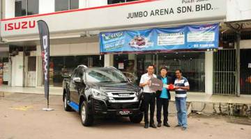 BERTUAH: Pengurus Besar Isuzu Malaysia, Kenkichi Sogo menyerahkan hadiah kepada Sugumaran di bilik pameran Isuzu Jumbo Arena, di Kluang.