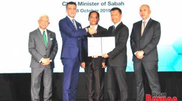 MENYAKSIKAN: Jaujan (tengah) menyaksikan pertukaran Perjanjian Akses diantara Maxis Berhad dan Celcom Timur Sabah.