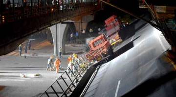 INSIDEN MALANG: Kenderaan dan anggota penyelamat dilihat bekerja di tapak di mana sebuah jejambat lebuh raya runtuh                          di Wuxi, wilayah Jiangsu, China kelmarin. — Gambar China Daily/Reuters