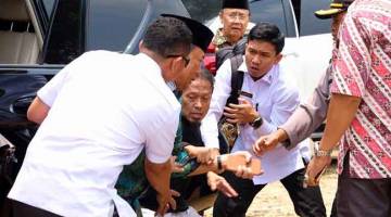 SAAT MENCEMASKAN: Gambar Antara Foto menunjukkan Wiranto diserang ketika lawatannya di Pandeglang, wilayah Banten, Indonesia kelmarin. — Gambar Antara Foto/Reuters 