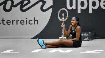 DETIK BERSEJARAH:  Gauff memberikan ‘pose’ istimewa bersama trofi ketika merikan kejayaan memenangi kejuaraan WTA yang pertama dalam kariernya di Linz, Austria kelmarin. — Gambar AFP 