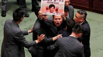 KECOH: Penggubal undang-undang prodemokrasi diheret keluar oleh pengawal keselamatan ketika Lam menjawab soalan daripada penggubal undang-undang berhubung dengan ucapan dasarnya di dewan undangan di Hong Kong, China semalam. — Gambar Kim Kyung-Hoon/Reuters
