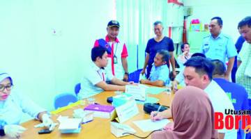 DAFTAR: Mohd Fazdli (tiga kiri) meninjau pendaftaran pegawai serta anggota PTS Sandakan bagi mendapatkan suntikan vaksin.