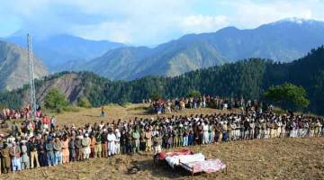 BERDARAH LAGI: Penduduk melakukan solat jenazah untuk mangsa serangan di sektor Nosari, Kashmir Pakistan kelmarin. — Gambar AFP