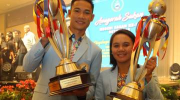 TERBAIK: Rayzam dan Fatin bersama piala Olahragawan dan Olahragawati Terbaik Sabah yang mereka menangi pada Majlis Anugerah Sukan Negeri Sabah 2017/2018 di Kota Kinabalu malam semalam.