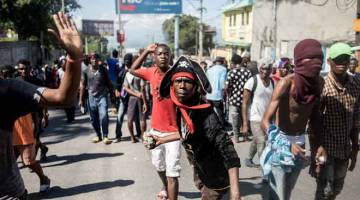 LANTANG: Pegawai polis dan para penyokong mereka memprotes di Port-au-Prince, kelmarin. — Gambar AFP