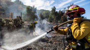 BERTUNGKUS-LUMUS: Bomba daripada Santa Fe Springs berusaha mengawal titik Kebakaran Maria, di Santa Paula, wilayah Ventura, California kelmarin. — Gambar Apu Gomes / AFP