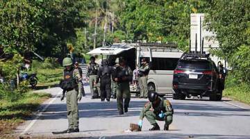 CARI PETUNJUK: Anggota skuad bom memeriksa tapak serangan di mana pemberontak Islam disyaki menembak mati 15 orang di wilayah Yala, selatan Thailand semalam. — Gambar Tuwaedaniya Meringing/AFP