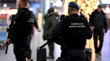 BERJAGA-JAGA: Anggota polis dilihat berkawal di lapangan terbang Schiphol, Amsterdam selepas satu amaran rampasan palsu dikeluarkan kelmarin. — Gambar Piroschka van de Wouw/Reuters