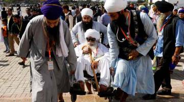 TERUJA: Penganut Sikh dari India berduyun-duyun melawat Gurdwara Darbar Sahib di Kartarpur, Pakistan kelmarin. — Gambar Reuters
