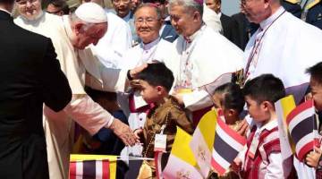 MESRA: Gambar serahan Jawatankuasa Penganjur Thai semalam menunjukkan Pope Francis              beramah mesra dengan kanak-kanak yang menyambut ketibaannya dalam rangka pertama jelajah Asia di Lapangan Terbang Antarabangsa Don Mueang di Bangkok, Thailand. — Gambar AFP