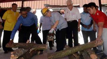 MELANCARKAN: Lim memotong dahan pokok menggunakan mesin gergaji berantai (chainsaw) pada Program Latihan Pengurusan Krisis dan Sumbangan Mesin Chainsaw Kawasan Parlimen Bagan semalam.  — Gambar Bernama