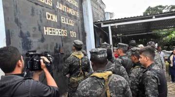 TERKAWAL: Anggota tentera tiba di luar fasiliti di Tela semasa pertelingkahan antara banduan samseng di Honduras, kelmarin. — Gambar Reuters