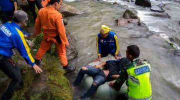 MENYAYAT HATI:  Gambar serahan BASARNAS semalam menunjukkan anggota penyelamat menemukan mayat seorang mangsa nahas di kampung Perahu Dipo, Pagar Alam, Sumatera Selatan. — Gambar AFP