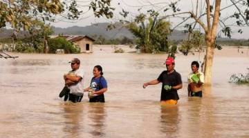 Penduduk meredah banjir akibat taufan Phanfone di Ormoc City, wilayah Leyte.
