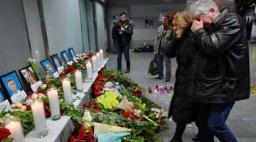 SEDIH: Ahli keluarga meratap semasa memberi penghormatan terakhir kepada mangsa pesawat Ukraine yang terhempas di Tehran, Iran di lapangan terbang Boryspil di pinggir Kiev, Ukraine kelmarin. — Gambar Sergei Supinsky/AFP