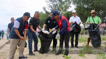 BERSIH: Daud bersama peserta yang hadir membersihkan kawasan pantai. 