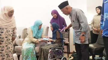 SUMBANGAN: Nur Arifah Bahiyah (tengah) menerima sumbangan YNJ daripada Toh Puan Norlidah sambil diperhatikan Naimah (kiri).