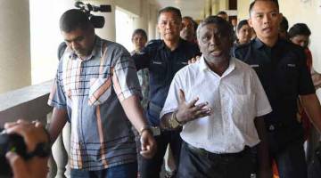 DIBICARAKAN: S. Chandru (kiri) mengaku tidak bersalah di Mahkamah Tinggi Kuala Lumpur semalam atas tiga pertuduhan berkaitan kumpulan pengganas LTTE. — Gambar Bernama