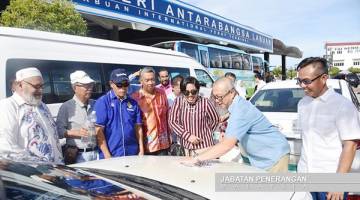 TMM 2020: Ahli Parlimen Labuan, Datuk Rozman Isli melekatkan logo Tahun Melawat Malaysia 2020 (TMM 2020) di sebuah teksi di Terminal Feri Penumpang Antarabangsa Labuan, baru-baru ini. Turut kelihatan Fary  (tiga kanan).