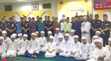 KENANGAN: Habibi (tengah)bergambar dengan para jemaah sejurus selepas menunaikan solat Jumaat bersama penduduk kampung  di Masjid Muhajirin Kampung Warisan, Inanam.  