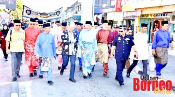 BERARAK: Hajiji (lima kanan) bersama umat Islam lain menyertai perarakan dari Padang Istiadat Daerah Tuaran ke Dewan Sri Sulaman.