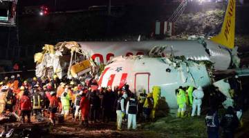 MALANG: Penyelamat membantu mengeluarkan penumpang dari pesawat Pegasus selepas ia tergelincir dari landasan ketika mendarat di lapangan terbang Sabiha Gokcen di Istanbul, Turki kelmarin. — Gambar AFP 